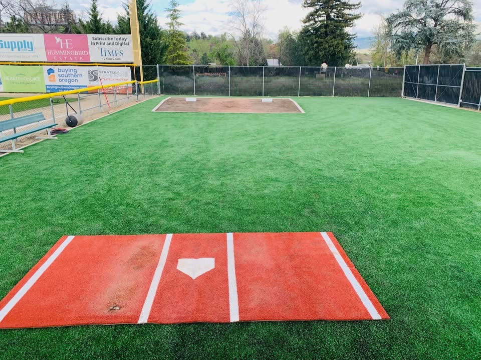 Bullpen and warm-up area at Harry & David Field in Medford, Oregon &mdash; turf practice mound and home plate mat ready for the American Legion Baseball Northwest Regional.